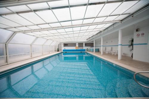 une grande piscine avec un plafond dans l'établissement Hotel Feira Pedra Bela, à Santa Maria da Feira