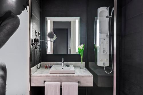 a bathroom with a sink and a mirror at Occidental Castellana Norte in Madrid