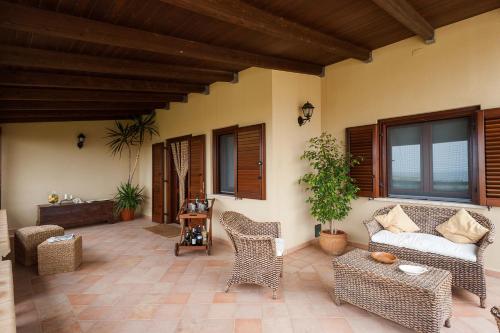 a patio with wicker chairs and a couch at Villa Baia Verde in Custonaci