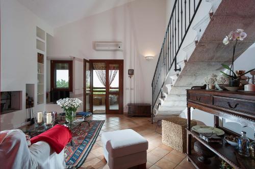 sala de estar con escalera y mesa en Villa Baia Verde, en Custonaci