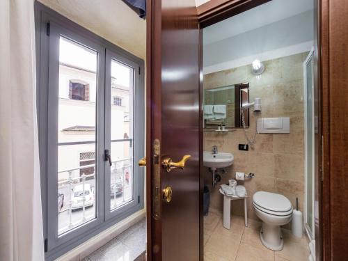 a bathroom with a toilet and a sink and a window at Hotel Aurora in Milan