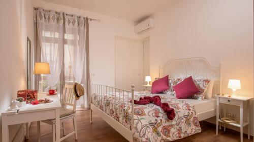 a bedroom with a white bed with pink pillows at Sweet Rooms Piramide Bed and Breakfast in Rome