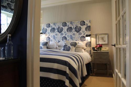a bedroom with a bed with blue and white pillows at The Broadway Hotel in Broadway