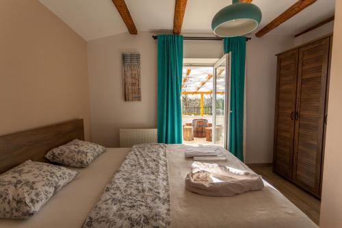 sypialnia z dużym łóżkiem z niebieskimi zasłonami w obiekcie Villa Hrustika - heated pool, jacuzzi & sauna w mieście Gabonjin
