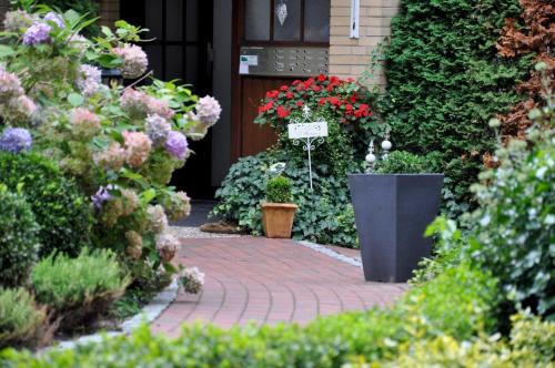 a garden with flowers and a sign on a brick walkway at Ferienwohnung Sperlingslust in Bad Bevensen