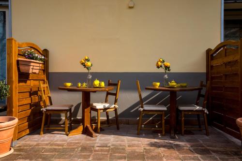two tables and chairs in a restaurant with flowers on them at Capriccio Di Pasta Residence & Spa in Gragnano