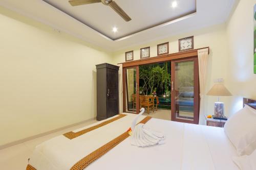 a bedroom with a bed and a large window at The Tunjung Ubud Retreat in Ubud