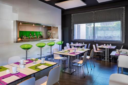 a dining room with tables and green chairs at Hotel Zentral Castellana Norte in Madrid