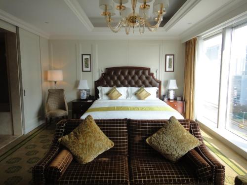 a bedroom with a large bed and a couch at The Langham, Shenzhen in Shenzhen