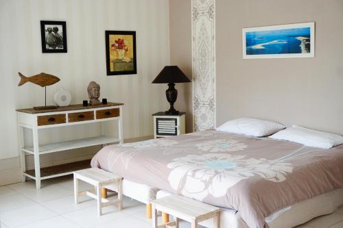 a bedroom with a bed and a table and a lamp at Villa Marie Suzon - Belle propriété pour 16 personnes à 5 mn de la Hume in Gujan-Mestras
