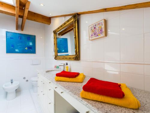 a bathroom with red and yellow towels on a counter at Apartment Pical in Poreč