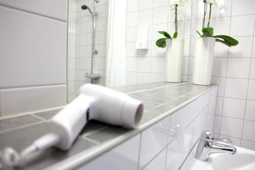 a bathroom with a sink and two vases on a shelf at Hotell Aston in Karlskrona