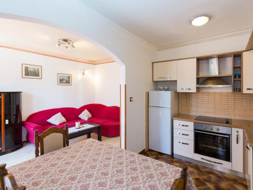 eine Küche und ein Wohnzimmer mit einem roten Sofa in der Unterkunft Apartment Nerina in Poreč