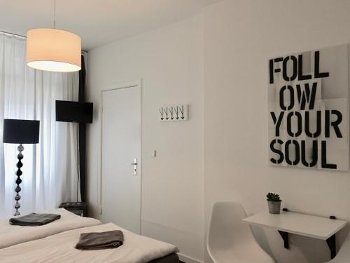 ハンブルクにあるNice n' Nordic 4のベッド2台、テーブル、ランプが備わる客室です。
