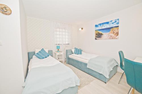 ソポトにあるLa Playa by Grand Apartmentsのベッドルーム1室(ベッド2台、テーブル、椅子付)