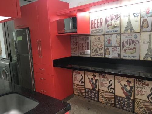 a kitchen with a red wall with posters on the wall at Mi casa es su casa in Lima