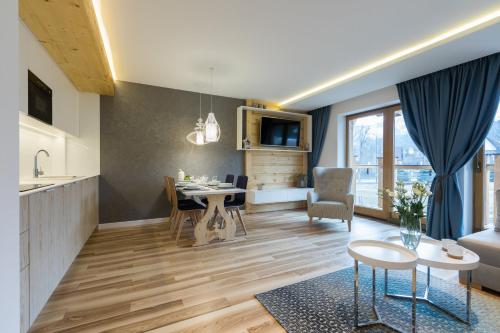 a living room with a kitchen and a dining room at Rezydencja Zakopiańska in Zakopane