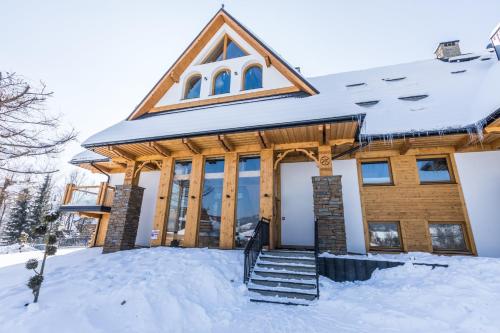 a home with snow on the ground at Rezydencja Zakopiańska in Zakopane