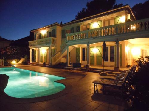 - un grand bâtiment avec une piscine la nuit dans l'établissement La Bastide Fleurie, à Cavalaire-sur-Mer