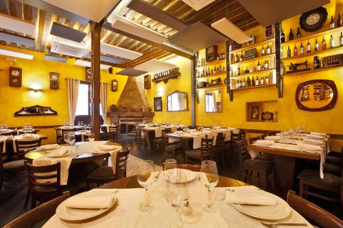 a restaurant with tables and chairs in a room with yellow walls at Apartamentos El Tiempo in Madrid