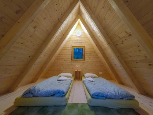 two beds in the attic of a log cabin at Camp Podljubelj in Podljubelj