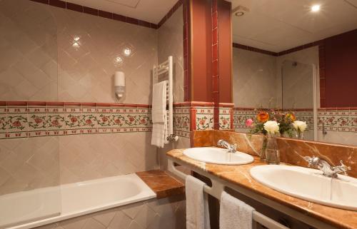 a bathroom with two sinks and a bath tub at Agora Juan de Austria in Madrid