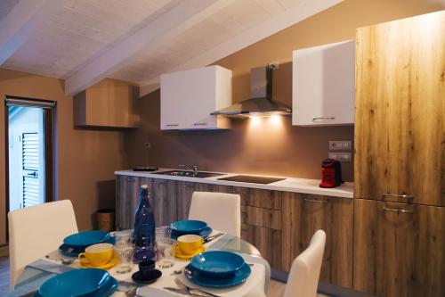 a kitchen with a table with blue dishes on it at Relais Monti Apartments in Vallo della Lucania