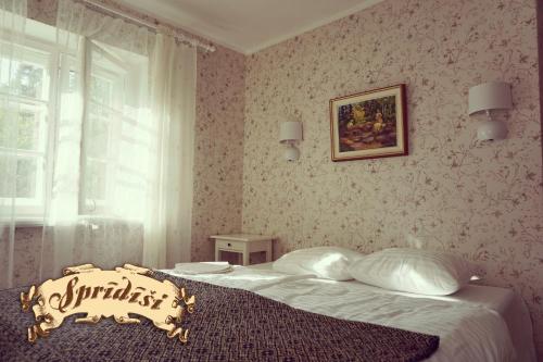 a bedroom with a bed with a comforter on it at Viesu māja Sprīdīši in Tērvete