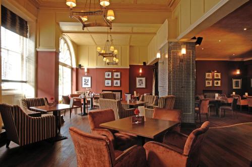 a restaurant with tables and chairs in a room at White Swan Hotel in Alnwick