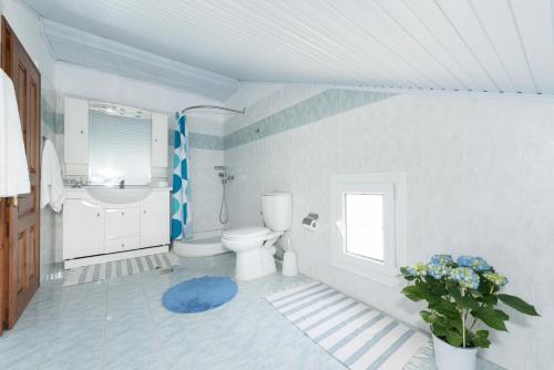 a white bathroom with a toilet and a sink at Corfu Villa Kokkini with swimming pool in Kokkínion