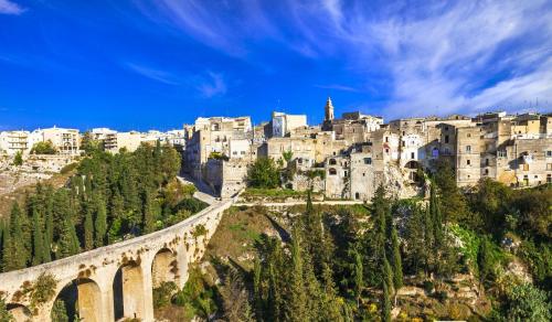 an old bridge over a mountain with a city at The Bridge Suites in Gravina in Puglia