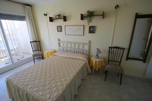 ミアミ・プラトーヤにあるVilla Adriana 303のベッドルーム1室(ベッド1台、椅子2脚、鏡付)