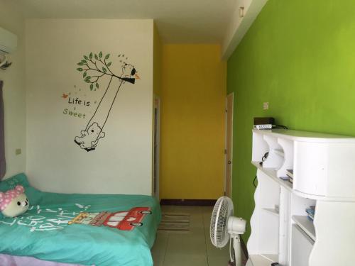 Cette chambre comprend un lit et un mur vert. dans l'établissement 隨緣居, à Huxi