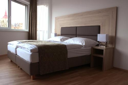 a bedroom with a large bed and a lamp on a table at Albert Schweitzer Center Graz in Graz