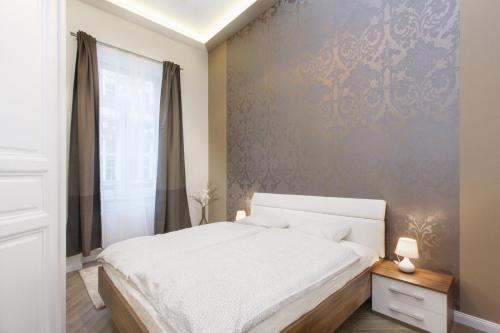 a bedroom with a white bed and a wall at Jenny luxury two bedrooms apartment. in Budapest