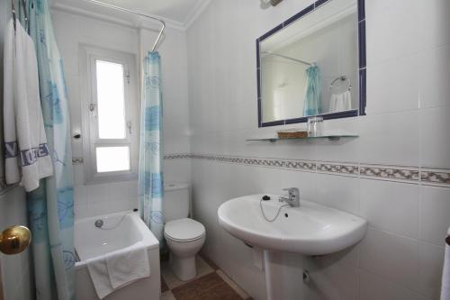 a white bathroom with a sink and a toilet at Hotel Sevilla in Almería