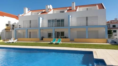 eine Villa mit einem Pool vor einem Haus in der Unterkunft Townhous Praia da Areia Branca in Praia da Areia Branca