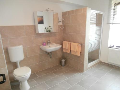 a bathroom with a toilet and a sink at Gästehaus Pension Heß - Das kleine Hotel in Güstrow
