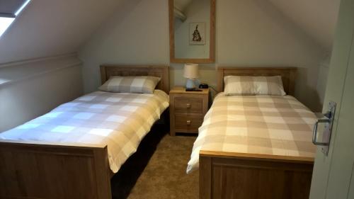 two beds sitting next to each other in a room at Warren Carr Courtyard Barn in Stanton in Peak