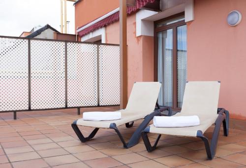 two white chairs sitting on a balcony at Agora Juan de Austria in Madrid
