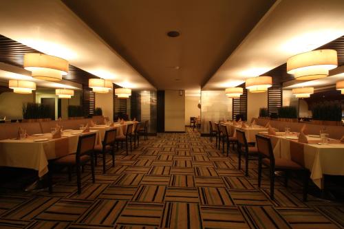 a dining room with tables and chairs and lights at Minerva Grand Secunderabad in Hyderabad