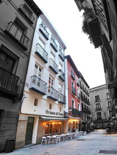a building with tables and chairs on a street at Apartamentos El Tiempo Madrid in Madrid