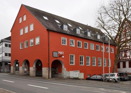 アシャッフェンブルクにあるTrip Inn PostApart Aschaffenburgの通路脇の大きな赤い建物