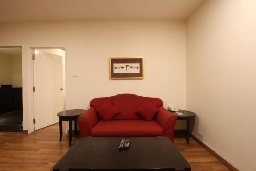 a living room with a red couch and a table at Minerva Grand Secunderabad in Hyderabad