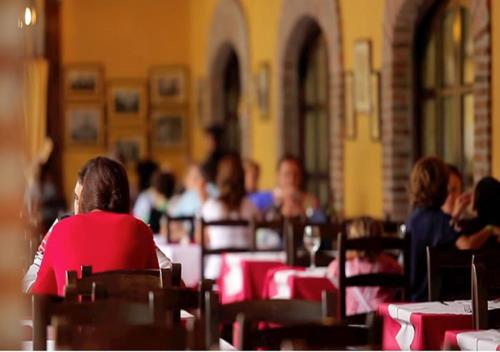 
people sitting at tables in a restaurant at Hotel El Bricial in Soto de Cangas
