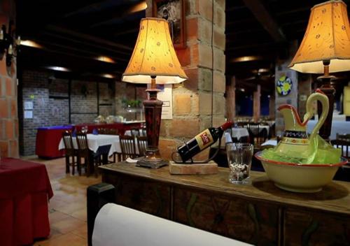 una mesa con una botella de vino y una lámpara en Hotel El Bricial, en Soto de Cangas