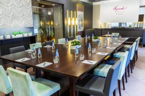 a dining room with a long table and chairs at Hotel Kossak in Kraków