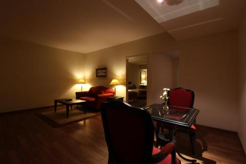 a living room with a couch and a table and chairs at Minerva Grand Secunderabad in Hyderabad