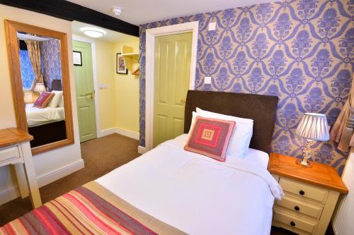 a bedroom with a bed with a pillow on it at The Royal Victoria and Bull Hotel in Dartford