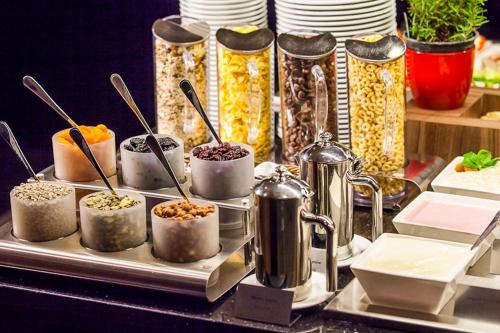 a buffet with several containers of food on a table at Qubus Hotel Kielce in Kielce
